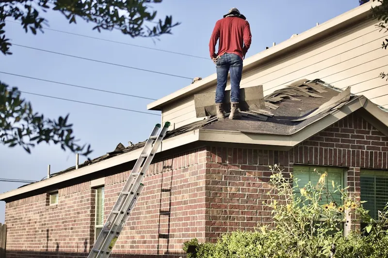 Professional roofer working on a residential roof in Falcon Ridge